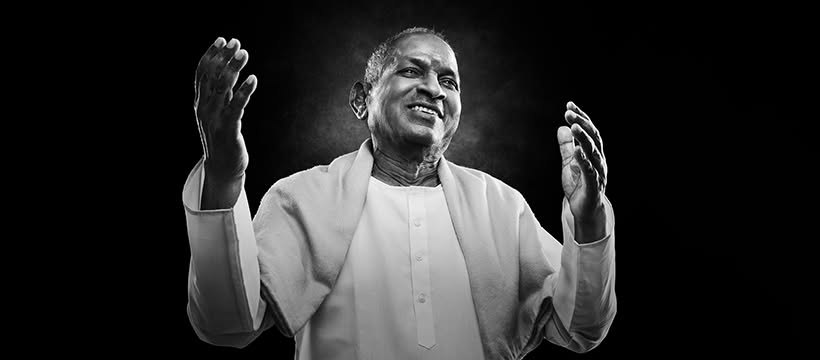 இளையராஜா மேடையில், இரு கைகளையும் உயர்த்தியபடி